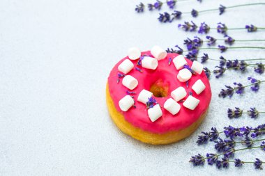 Mini marşmelovla kaplı parlak pembe çörek kokulu lavanta çiçeklerinin yanında oturur. Sahne neşeli ve rahatlatıcı bir atmosferde enfes bir ziyafet çekiyor..