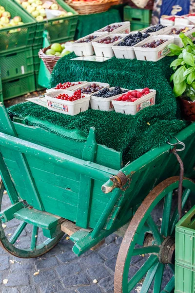 食料品店のインテリアや農家市場で素朴な緑の塗られた木製のカートに表示された新鮮な果実の選択 — ストック写真