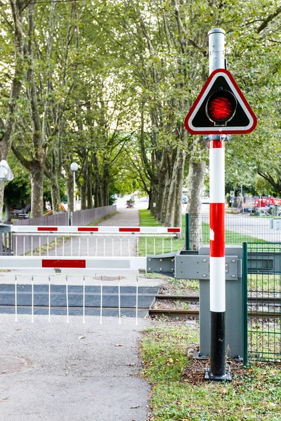 Ländlicher Bahnübergang Mit Heruntergelassenen Signalanlagen Und Roter Warnlampe Die Den Stockbild
