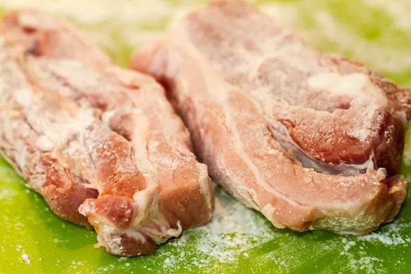 Close Two Salted Seasoned Pork Boin Chops Green Background Surface — Stock fotografie