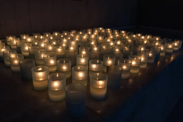教堂里桌子上单个玻璃器皿中的一大串点燃的蜡烛 — 图库照片