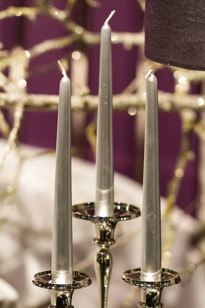 Close Up of Three Silver Taper Candles Mounted in Classic Silver Candelabra as part of Home Decor or Decoration at Event