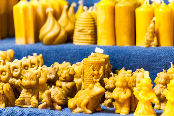 Display on shelves of decorative candles in a variety of shapes some depicting animals and figures in a close up view