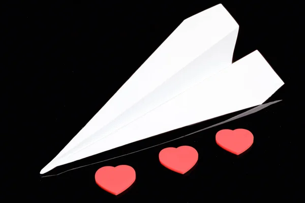 Бумажный Самолет Три Пластиковых Красных Сердца — стоковое фото