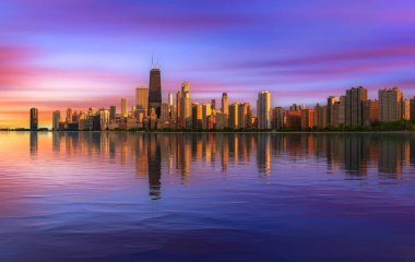 Chicago 'nun üzerindeki renkli günbatımı Michigan Gölü boyunca ufuk çizgisi ve suda yansıması.