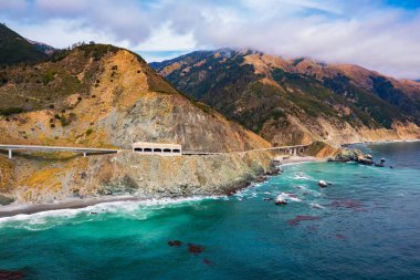 Pitkins Curve Bridge ve Rain Rocks Rock Shed 'in Kaliforniya' daki Pacific Coast Highway ve Big Sur sahil şeridi boyunca havadan görüntüsü..