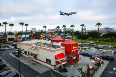 Los Angeles, Kaliforniya, ABD - 26 Mayıs 2022: Alaska Havayolları, Los Angeles Uluslararası Havaalanı 'na inerken eski bir In-N-Out Burger restoranının üzerinde uçuyor..