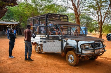 Bandia, Senegal - 26 Şubat 2023: Bir araba kafesinde turistler Senegal 'deki Ranch de Bandia' da aslanları ziyaret etmeye hazırlanıyorlar