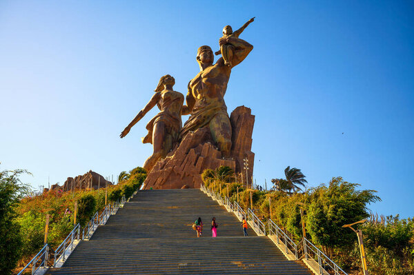 Dakar, Senegal - March 01, 2023 : Statue called Monument of the African Renaissance with tourists walking towards it.