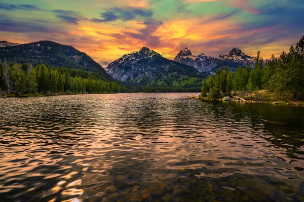 ABD 'nin Wyoming şehrinde Taggart Gölü ve Grand Teton Dağları üzerinde gün batımı. Taggart Gölü Grand Teton Ulusal Parkı 'nda görkemli dağlarla çevrili çarpıcı bir alp gölüdür..