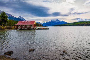 Maligne Gölü, Alberta, Kanada - 23 Eylül 2021: Kanada Jasper Ulusal Parkı 'ndaki Maligne Gölü' nde kayıkhane, arka planda Kanada Rocky Dağları 'nın karla kaplı zirveleri.