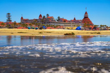 San Diego, Kaliforniya, ABD - 20 Haziran 2023: Hotel del Coronado açık bir günde sahilden izlendi. San Diego 'da Viktorya dönemi mimarisi ile ünlü tarihi bir sahil beldesidir..