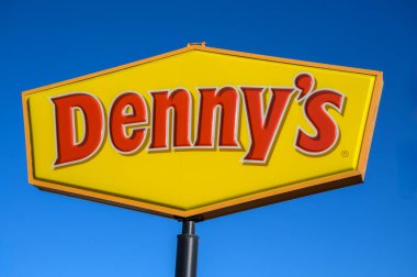 Ridgecrest, Kaliforniya, ABD - 11 Kasım 2023: Denny 'nin restoran tabelası ve mavi gökyüzüne karşı logo. Denny 's, gece gündüz yemek servisi yapan popüler bir Amerikan lokanta zinciri..