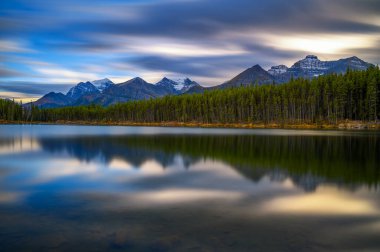 Kanada 'nın Alberta kentindeki Banff Ulusal Parkı' ndaki Icefields Parkway 'in yol kenarındaki Herbert Gölü üzerinde gün batımı. Uzun pozlama.