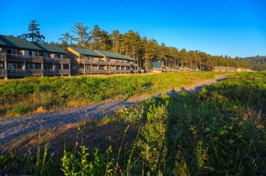 Quillayute, Washington, ABD - 12 Haziran 2023: Quileute Oceanside Resort, La Push Sahili üzerinde gün batımında ağaçların arasında konaklama.