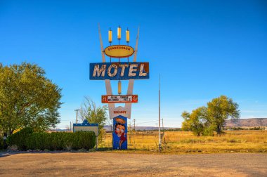 Seligman, Arizona, ABD - 4 Kasım 2023: Seligman, Arizona 'da tarihi Route 66 üzerinde bulunan Posta Arabası 66 Motel tabelası ve binası, açık bir gökyüzü altında nostaljik bir yol manzarası yakalar..