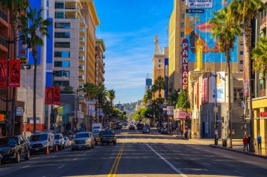Hollywood, California, ABD - 14 Kasım 2023: Hollywood Bulvarı 'nın güneşli manzarası Palmiye ağaçları, arabalar ve Pantages Tiyatrosu gibi ikonik binalar.