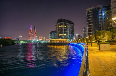 Manama, Bahreyn - 27 Aralık 2023: Bahreyn Dünya Ticaret Merkezi 'nin Balık Pazarı Restoranı, Dört Mevsim Konutu ve Bahreyn Körfezi Konutu ile suya yansıması.