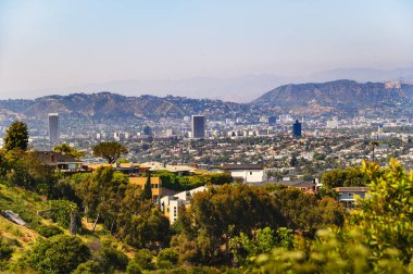 Los Angeles 'taki Kenneth Hahn Parkı' ndan Hollywood manzaralı ve arka planda dağlar var.