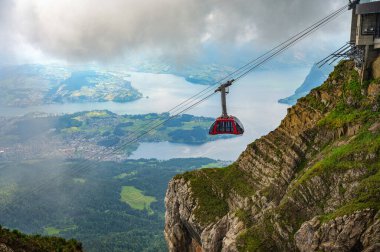 İsviçre 'deki Pilatus Dağı' na yaklaşan teleferik, sis ve bulutların arasında Lucerne Gölü 'nden görülebiliyor..
