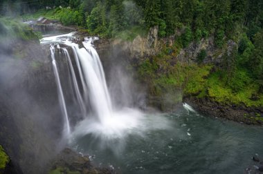 Washington State, ABD 'de yemyeşil ve sisli Snoqualmie Falls. Snoqualmie Şelalesi Snoqualmie ve Fall City arasındaki Snoqualmie nehrinin 220 metrelik bir şelalesidir. Uzun pozlama.