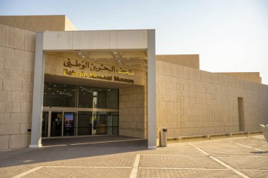 Manama, Bahreyn - 24 Aralık 2023: Manama 'daki Bahreyn Ulusal Müzesi' nin dış görünüşü, modern mimarinin Arapça ve İngilizce işaretleriyle sergilenmesi.