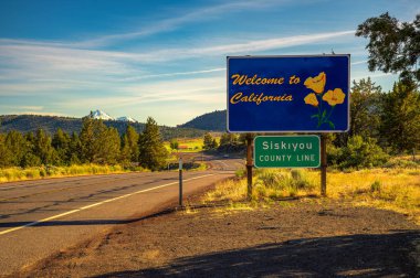 Siskiyou County, California, USA - June 15, 2023 : Welcome to California road sign located at the Siskiyou County border with Oregon, captured during golden hour shortly before sunset.  clipart