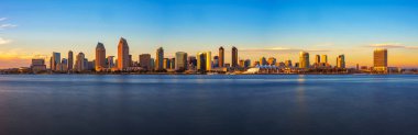 Panoramic view of San Diegos skyline at sunset, captured from Coronado Island with a long exposure, highlighting calm waters and city lights. clipart