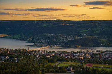 Lillehammer, Norveç 'in havadan görünüşü, yaz günbatımında, arka planda Mjosa Gölü ve çevresindeki tepeler.