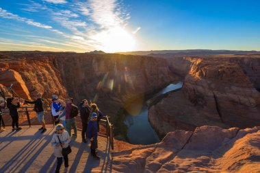Page, Arizona, ABD - 08 Kasım 2023: Ziyaretçiler, Colorado Nehri 'nin Page, Arizona yakınlarındaki kırmızı kaya kanyonlarında kıvrıldığı Horseshoe Bend' in manzaralı manzarasında toplandılar..