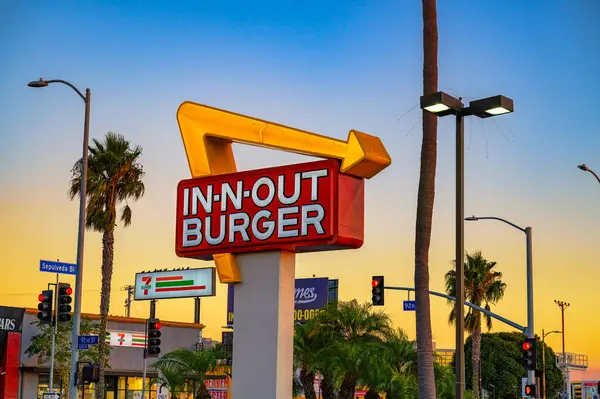 Los Angeles, Kaliforniya, ABD - 03 Kasım 2023 Los Angeles, Kaliforniya 'da gün batımında bir sokak köşesinde Iconic In-N-Out Burger tabelası.