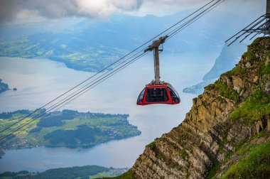İsviçre 'deki Pilatus Dağı' na yaklaşan teleferik, sis ve bulutların arasında Lucerne Gölü 'nden görülebiliyor..