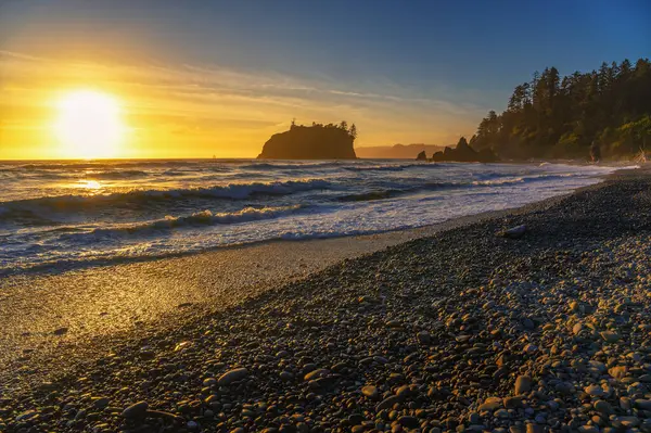 Ruby Sahili 'nde Pasifik Okyanusu' nun üzerinde renkli bir günbatımı dalgalar ve Washington eyaletindeki Olimpiyat Ulusal Parkı 'nda kayalık bir kıyı şeridi.