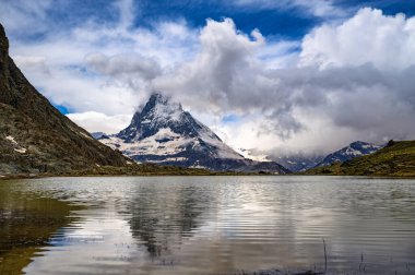 Karla kaplı Matterhorn, İsviçre 'deki Gornergrat Demiryolu yakınlarındaki Riffelsee Gölü' nde aynalanmış..