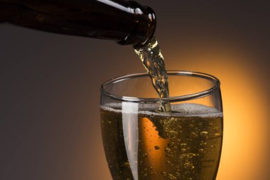 Bira şişeden cama hafif bir arka planla doluyor.