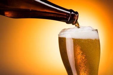 Bira şişeden cama hafif bir arka planla doluyor.