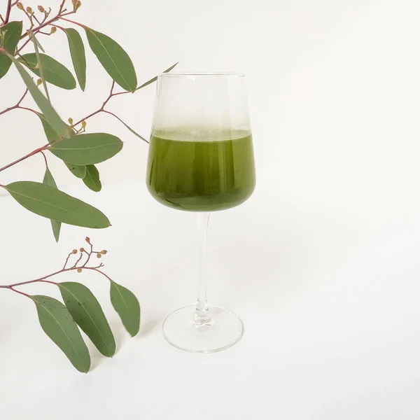 Green powder. Vitamins for life. Cocktail. Supplements. In a transparent glass. Light background. Cozy and healthy breakfast. High quality photo