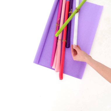 El renkli kağıda uzanıyor. Üst Manzara. Mesaj ve logo için yer. Eğitim, nakış, sanat, kırtasiye, ambalaj. Yüksek kalite fotoğraf