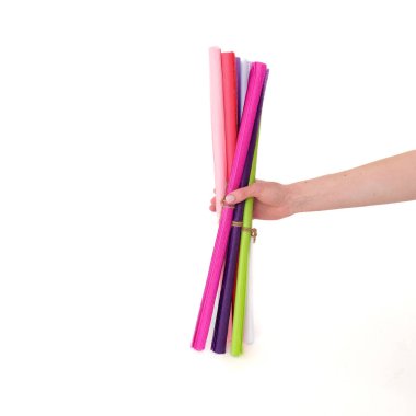 Beyaz arka planda renkli kağıtları tutan eller. Mesaj ve logo için yer. Paketleme, okul, eğitim, ofis, dikiş, sanat konsepti. Yüksek kalite fotoğraf