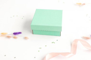 Turkuaz kutuya karşılık şenlik arka planı. Mesaj ve logo için yer. Hediye konsepti, tatil, ambalaj. Yüksek kalite fotoğraf