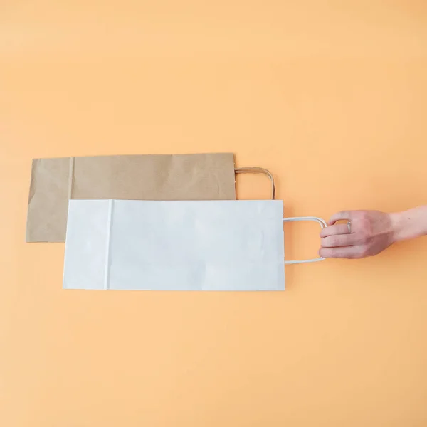Craft long packaging bags on an orange background. Place for text and logo. The concept of packaging, gift, drink, bottle packaging. High quality photo