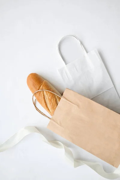 Beyaz arka planda bir somun ekmeği olan el işi çantalar. Mesaj ve logo için yer. Paketleme, yemek, alışveriş. Yüksek kalite fotoğraf