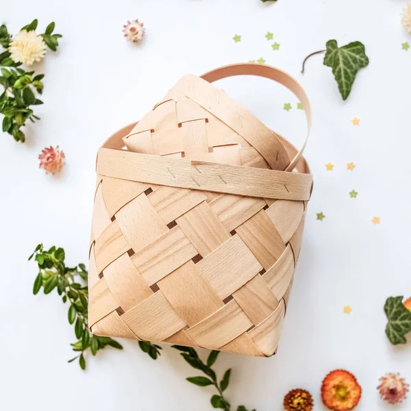Craft baskets on spring background with flowers and greenery. The concept of eco style, packaging, uniform style. Needlework. Decorating. High quality photo