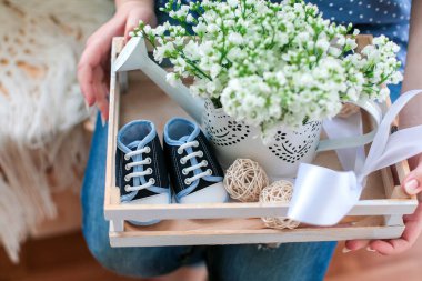 Hamilelik. Hamileliği bekliyorum. Bebekler için küçük kıyafetler. Çiçekler. Yüksek kalite fotoğraf