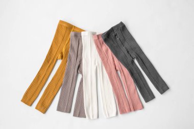 Çocuklar, çok renkli taytlar giyiyorlar. Beyaz arka plan. Üst Manzara. Çocuk kıyafetleri dolabı. Yüksek kalite fotoğraf