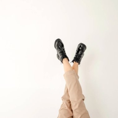 Beyaz arka planda siyah çizmeli bir kadın. Moda, tarz, kayıtsızlık, boş zaman, iş. Yüksek kalite fotoğraf