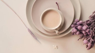 Mor çiçekli bej tabakta bir fincan kahve, üst manzara, yazı için yer, pankart. Yüksek kalite fotoğraf