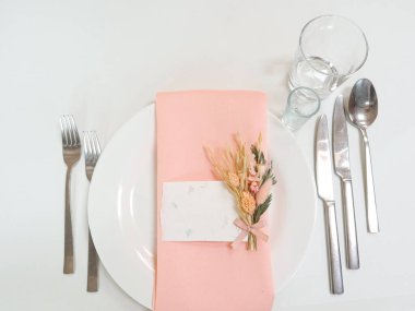 Düğün için masayı hazırlıyorum. Bir yazı kartı, tabaklar, beyaz bir masa örtüsü. Üst Manzara. Yüksek kalite fotoğraf