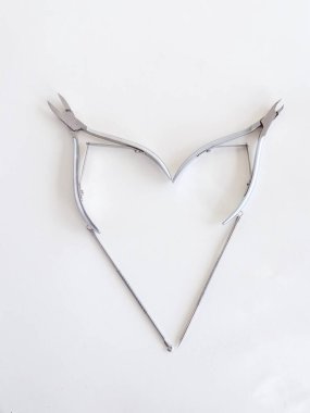 Manikür aletleri beyaz bir arka planda kalp şeklinde katlanır, üstten bakıldığında, metin için yer vardır. Güzellik salonu, bakım, estetik. Yüksek kalite fotoğraf