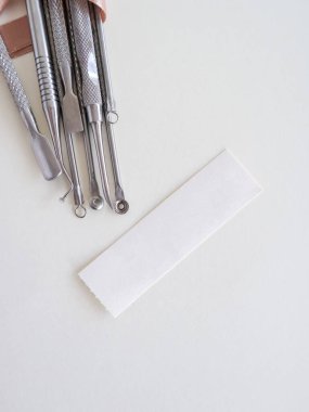 Beyaz arkaplanda manikür araçları, metin için boşluk, üst görünüm. Güzellik salonu, sterilizasyon, estetik. Yüksek kalite fotoğraf